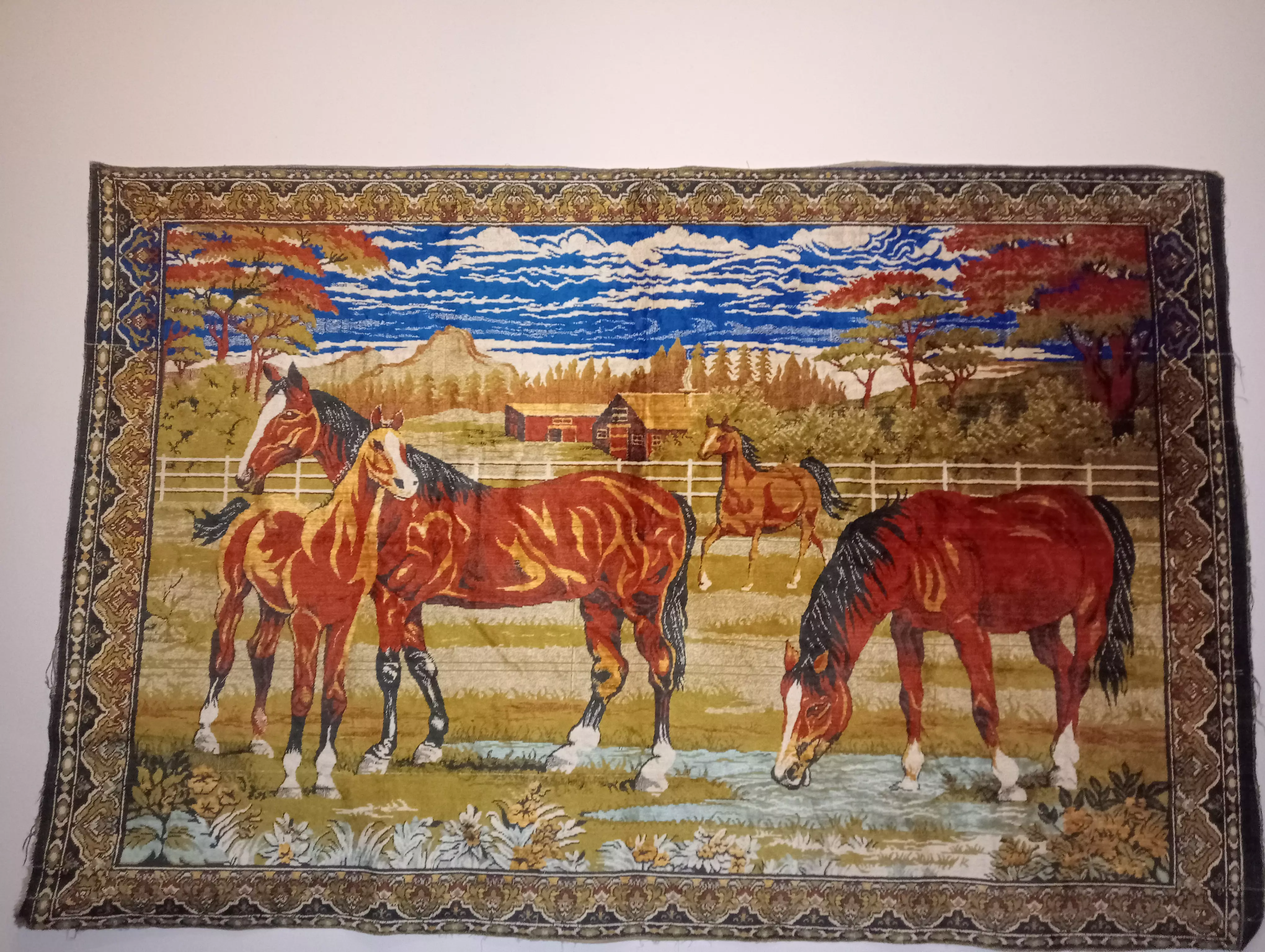 نسيج جداري يدوي الصنع بتصميم كلاسيكي فينتج أصيل، يُظهر مشهداً ريفياً خلاباً يضم: - **4 خيول** بألوان بنية دافئة مع لمسات ذهبية رائعة - **منظر طبيعي** ساحر مع سماء زرقاء وغيم بيضاء - **أشجار خريفية** بألوان برتقالية وحمراء - **منزل ريفي** وحظيرة في الخلفية